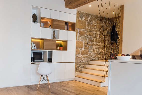 Alcôves de rangement en chêne naturel avec portes coulissantes intégrées.