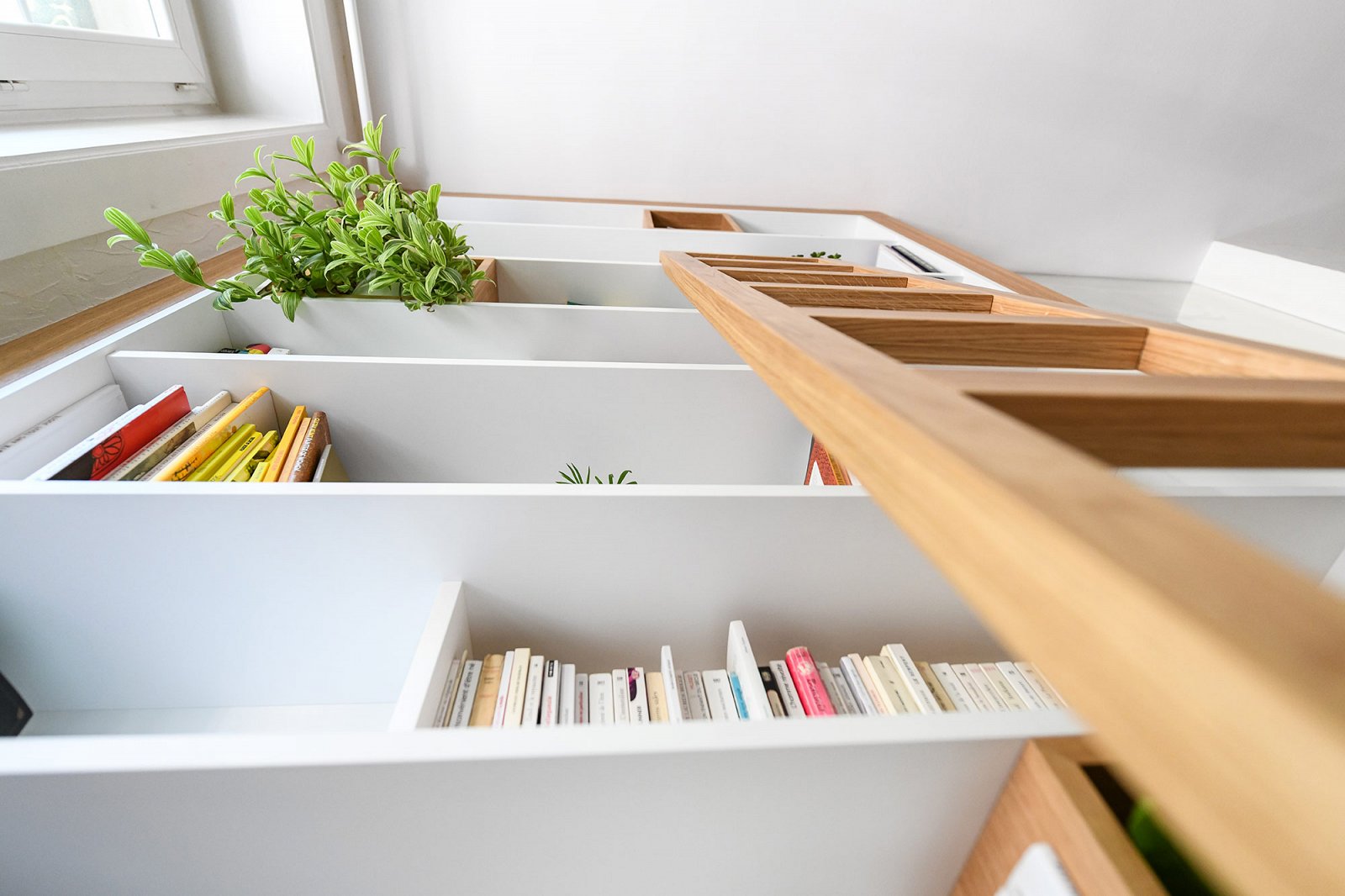 Bibliothèque sur mesure avec niches ouvertes et rangements intégrés dans un appartement haussmannien.