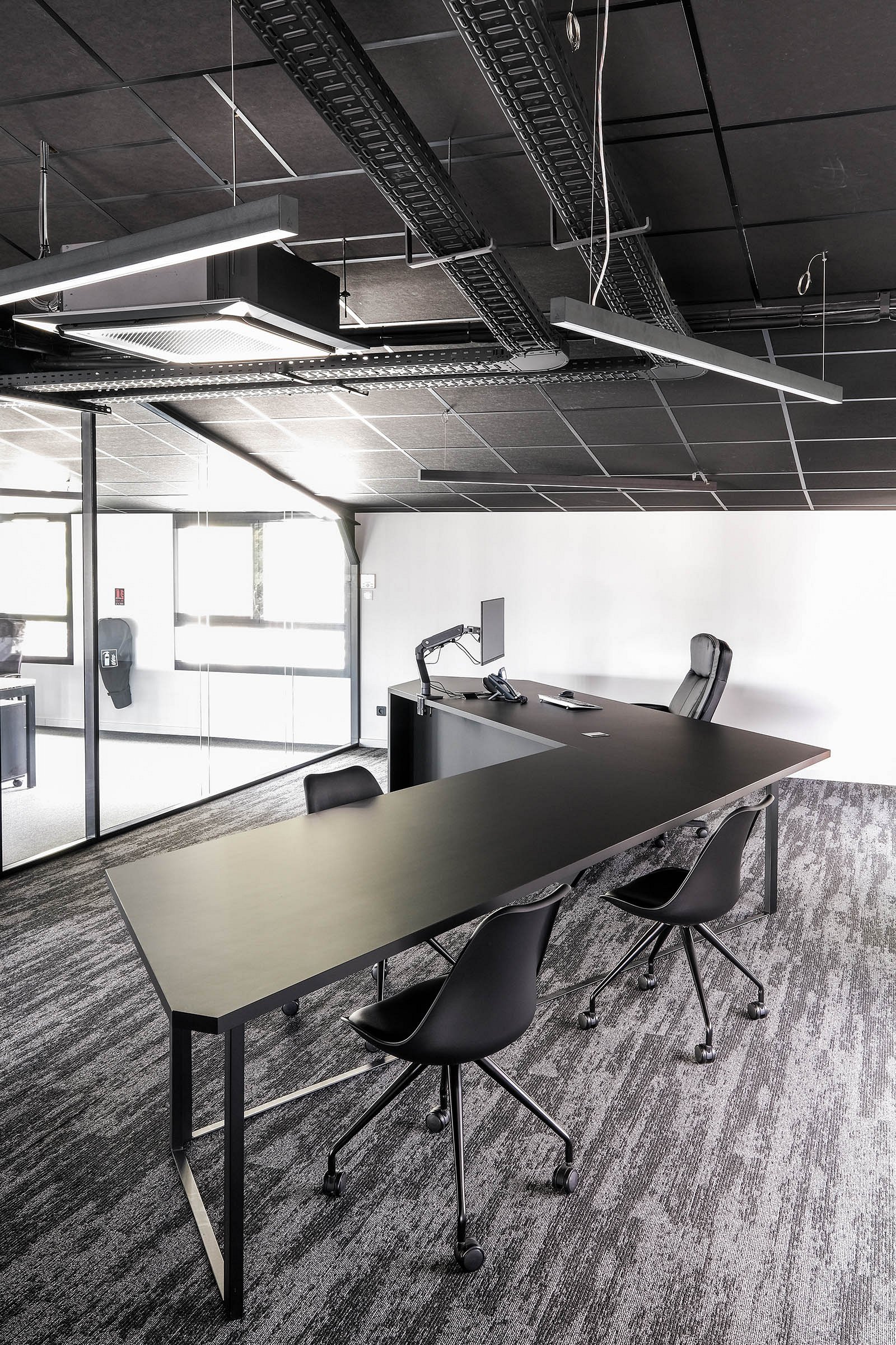 Table de réunion sur mesure intégrée à un bureau de direction.
