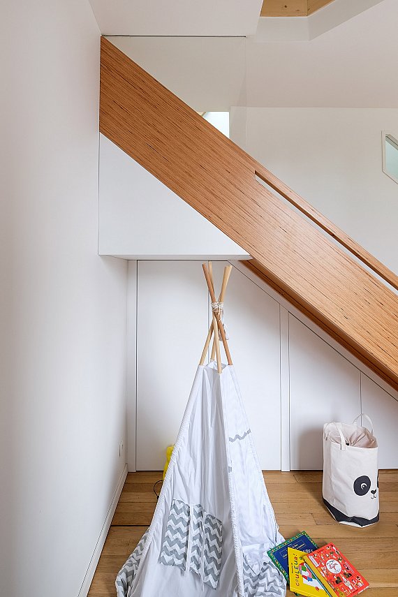 Toboggan en bois pour une salle de jeux avec éclairage LED et main courante intégrée.