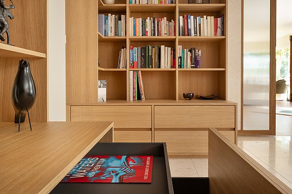 Étagères sur mesure en placage chêne intégrées à une bibliothèque contemporaine.