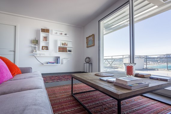 Bibliothèque murale flottante réalisée à Marseille pour structurer un salon contemporain.