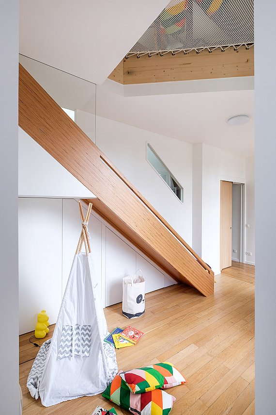 Placard à jouets intégré sous un toboggan sur mesure dans une salle de jeux.