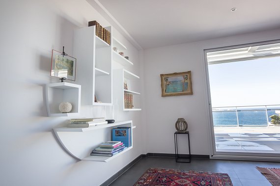 Composition d'étagères flottantes en panneaux laqués blanc réalisée à Marseille pour structurer un salon contemporain.